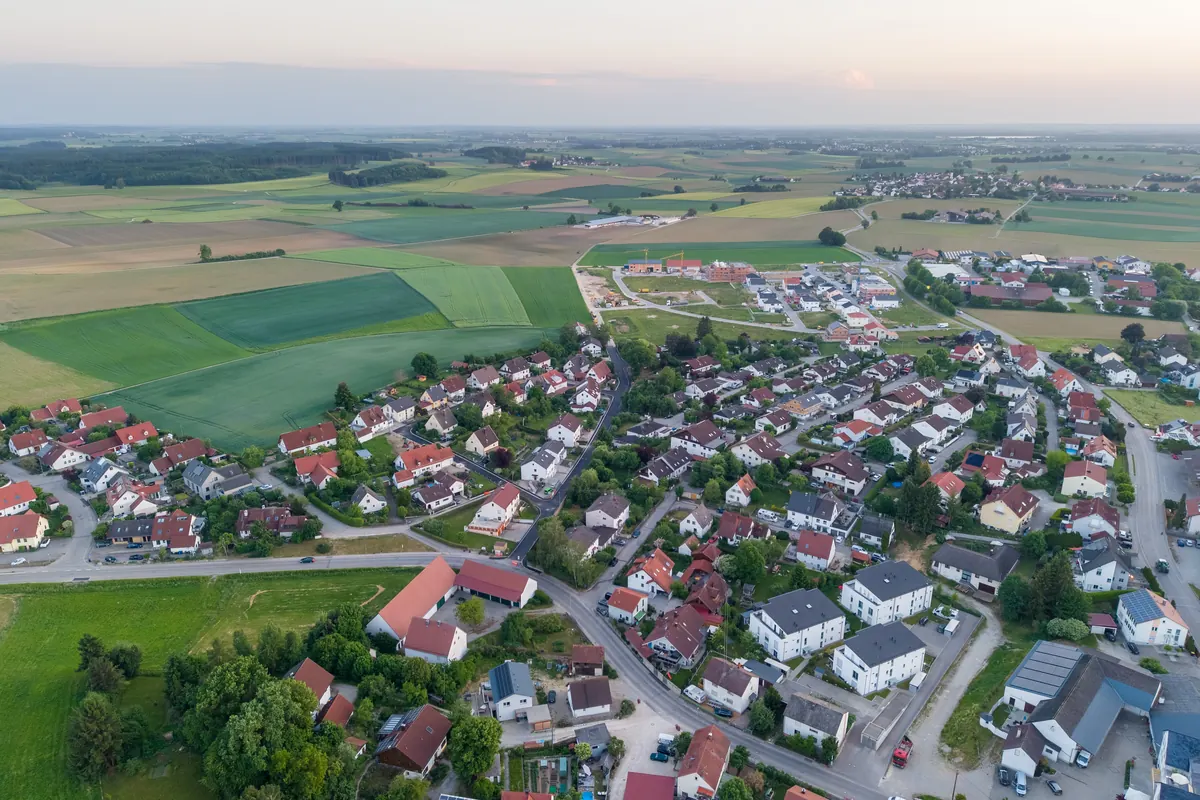 Luftaufnahme eines Neubaugebiets mit Einfamilienhäusern am Ortsrand von Ried, typische Lage erschlossener Baugrundstücke