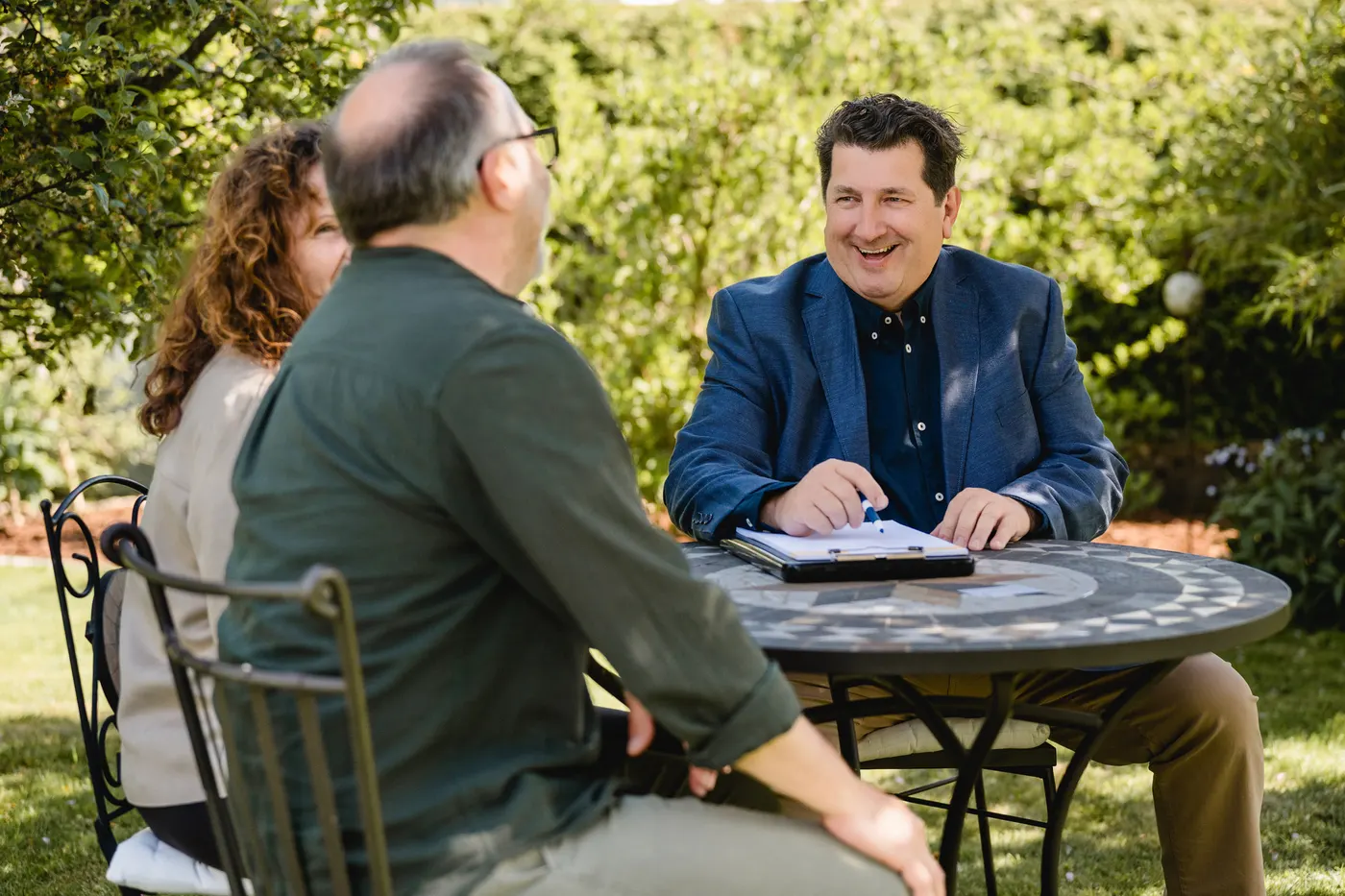 Alexander Köhler im Erstgespräch mit einem Eigentümerpaar am Gartentisch